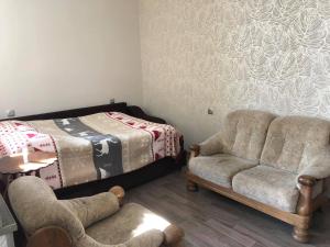 sala de estar con 2 sillas y 1 cama en Our house en Borjomi