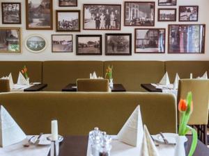 un comedor con mesas, sillas y cuadros en la pared en Hotel-Restaurant Zur Linde, en Secklendorf