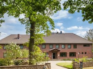 ein großes Backsteingebäude mit einem Baum davor in der Unterkunft Hotel-Restaurant Zur Linde in Secklendorf