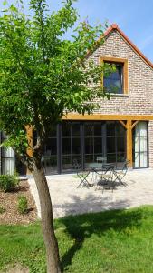 a table and chairs in front of a building at La Miellerie in Huppaye