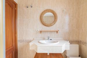 a bathroom with a white sink and a mirror at Adosado El Perenquen in Agaete +31 photos