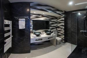 een badkamer met een wastafel en een spiegel bij Hôtel du Barry Resort & Spa in Sauveterre