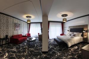 een hotelkamer met een bed en een rode bank bij Hôtel du Barry Resort & Spa in Sauveterre