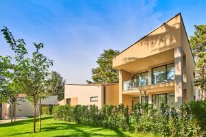 ein modernes Haus mit Garten davor in der Unterkunft Garden Suites Park Plava Laguna in Poreč