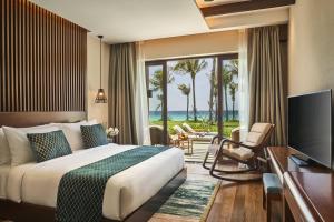 una habitación de hotel con una cama y una ventana grande en Mövenpick Resort Cam Ranh, en Cam Ranh