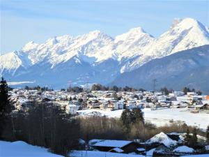 eine Stadt mit schneebedeckten Bergen im Hintergrund in der Unterkunft Cozy mountain view apartment with terrace and garden in Innsbruck