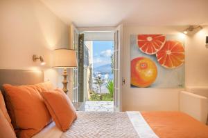 a bedroom with a bed and a painting of oranges at Villa Leondari by Rodostamo Collection in Ágios Stéfanos