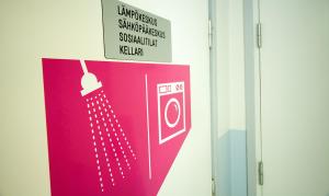 un cartel en una puerta con una foto de un inodoro en Yömyssy Apartments, en Kerimäki