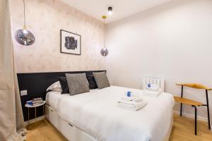een slaapkamer met 2 bedden en witte lakens bij CMG-Clery - Place des Victoires in Parijs