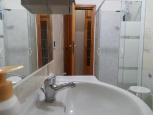 a bathroom sink with a faucet and a mirror at Casa Marilù in Alghero +27 photos