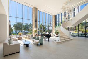 een lobby met een piano, stoelen en ramen bij Fleur de Lys Hotel Quy Nhon in Quy Nhon