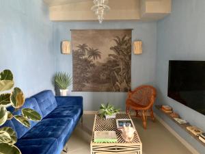 a living room with a blue couch and a tv at Okulus Madeira in Funchal