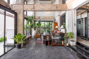 an industrial room with plants and a hallway with windows at IR-ON Hotel in Bangkok