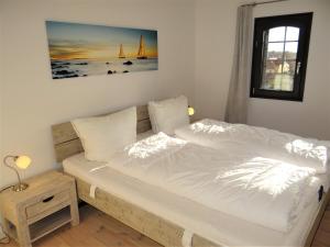 een slaapkamer met een groot bed met witte lakens bij Speicher Residenz Barth E4 App 10 in Barth