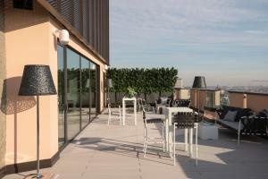 a balcony with tables and chairs on a building at Milan Eleven by Brera Apartments in Milan