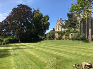 a large grass field in front of a mansion at Beryl Country House in Wells