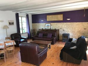 a living room with leather furniture and a brick wall at Cidrerie, Coeur De Combray in Ernes