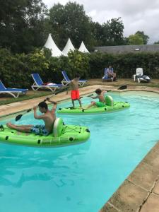 een groep mensen die op opblaasbare plekken in een zwembad rijden bij Cidrerie, Coeur De Combray in Ernes