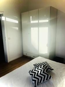 een slaapkamer met een wit bed en een zwart-wit kussen bij W - The Boutique Apartment in Warnemünde