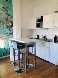 een keuken met een tafel en 2 krukken bij W - The Boutique Apartment in Warnemünde