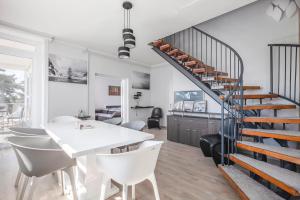 a dining room and living room with a spiral staircase at Mirador Balaton Panorama Villa & Jacuzzi in Balatonakarattya