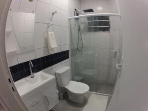 a bathroom with a shower and a toilet and a sink at Flats do Capitão S.A. in Ubatuba
