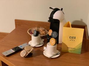 a table with two m cups and a bag of food at Hotel Cies in Calvarrasa de Abajo