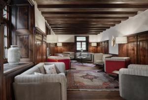 a living room with couches and chairs and wooden walls at Hotel Schwarzer Adler Innsbruck in Innsbruck