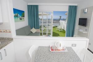 a view of a room with a table and a mirror at Vista Oasis in Maspalomas