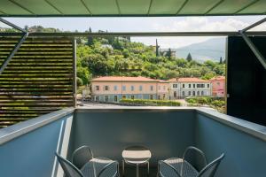 uma varanda com cadeiras, uma mesa e uma vista em Caravel Bike Hotel em Nago-Torbole