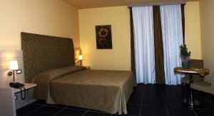 a hotel room with a bed and a window at Tus'Hotel in Castel di Tusa