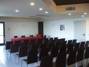 a conference room with a red table and chairs at Tus'Hotel in Castel di Tusa