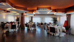 カステル・ディ・トゥーザにあるTus'Hotelのテーブルと椅子が備わる宴会場