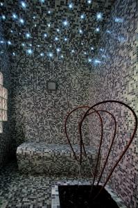 a room with a bench with lights on the ceiling at Tus'Hotel in Castel di Tusa