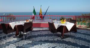 a table and chairs on a balcony with the ocean at Tus'Hotel in Castel di Tusa