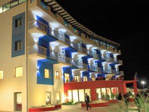 a man walking in front of a hotel at night at Tus'Hotel in Castel di Tusa