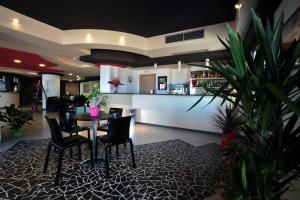 a restaurant with a table and chairs and a bar at Tus'Hotel in Castel di Tusa