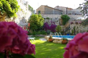 a garden with pink flowers in front of a building at B&B Villa Clodia in Saturnia
