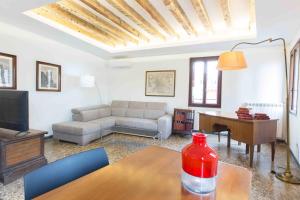 uma sala de estar com um sofá e uma mesa em CA GRIMANI Double Apartment: private terrace and stunning view em Veneza