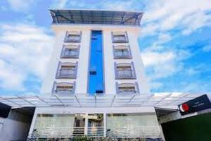 un grand bâtiment blanc avec une fenêtre bleue dans l'établissement Hotel Garden Inn, à Cochin