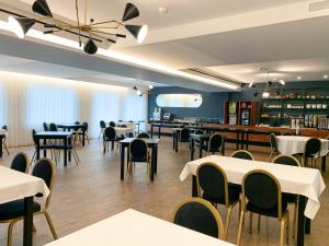 a restaurant with tables and chairs in a room at Hotel Moutados in Vila Nova de Famalicão