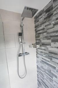 a shower with a shower head in a bathroom at Broadcroft Hotel in Kirkintilloch