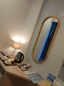 
a bathroom with a mirror and a sink at Flipper House Hotel - SHA Extra Plus in Pattaya
