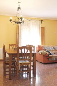 a dining room with a table and chairs and a couch at Vivienda Turística el Ciclamen in Mora de Rubielos