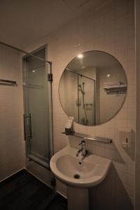 uma casa de banho com um lavatório e um espelho em The Bedrooms Boutique Hotel Bangkok em Bangkok