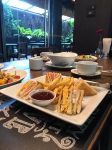 a plate of sandwiches and french fries on a table at The Bedrooms Boutique Hotel Bangkok in Bangkok