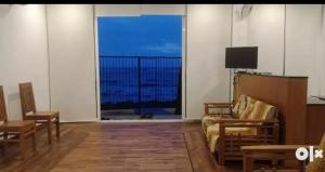 uma sala de estar com um sofá e uma grande janela em QUILON BEACH Inn em Coulão