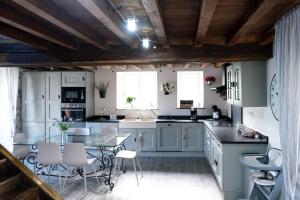 a kitchen with white cabinets and a glass table at Au Nid de Caroline gîte 4 étoiles in Arette