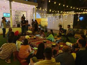 un grupo de personas sentadas alrededor de una mesa en una habitación en Urban Nomads Pune Riverside CoLive CoWork en Pune