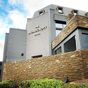 un edificio con una pared de ladrillo delante de él en Broadcroft Hotel, en Kirkintilloch